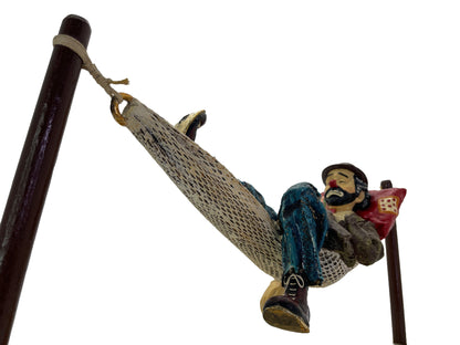 Low-angle view of a signed Ron Lee hobo clown sculpture showing the woven hammock, painted figure, and natural onyx base.