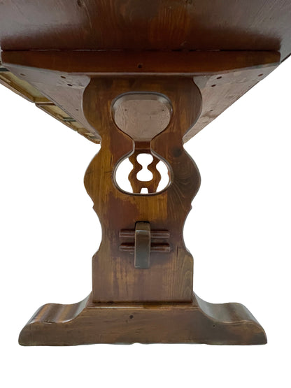 Detail of carved pedestal support and trestle base on an antique Victorian pine writing desk.
