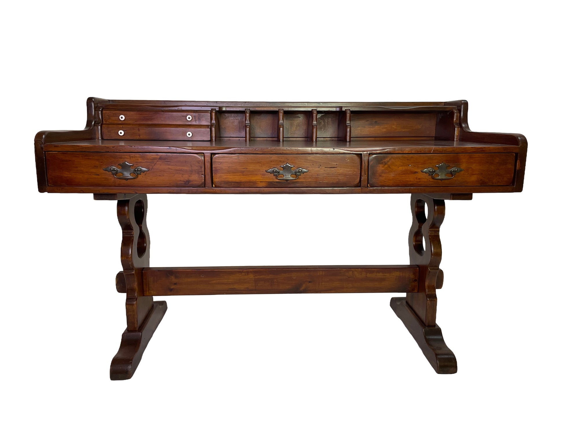 Angle view of an early 20th century Victorian solid pine writing desk with hutch and traditional trestle base.