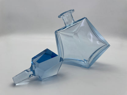 Vintage blue glass decanter with a sculptural geometric silhouette and removable faceted glass stopper.