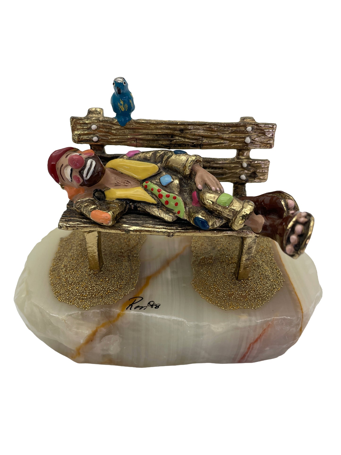 Vintage Ron Lee sleeping clown sculpture resting on a park bench with a blue bird, hand-painted with 24K gold-plated finish on a natural onyx base, signed 1988.