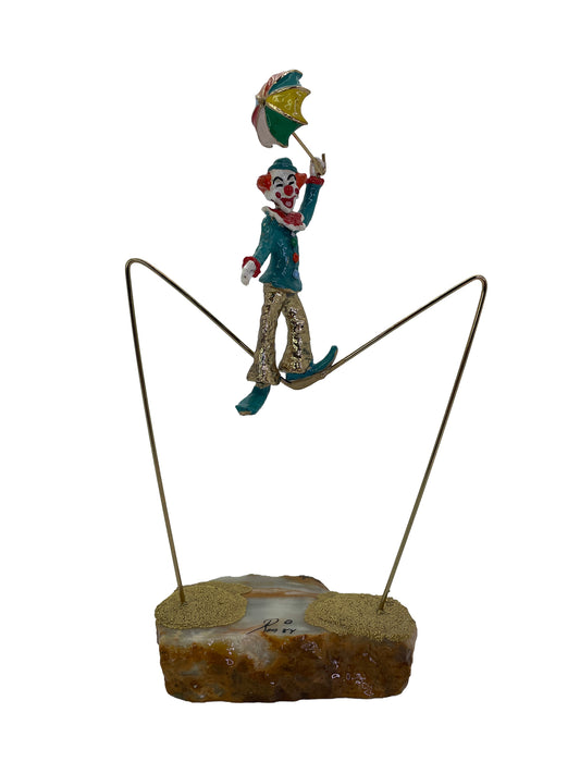 Vintage Ron Lee High Wire Circus Clown sculpture balancing on a brass tightrope with colorful umbrella and natural onyx base, signed 1984.