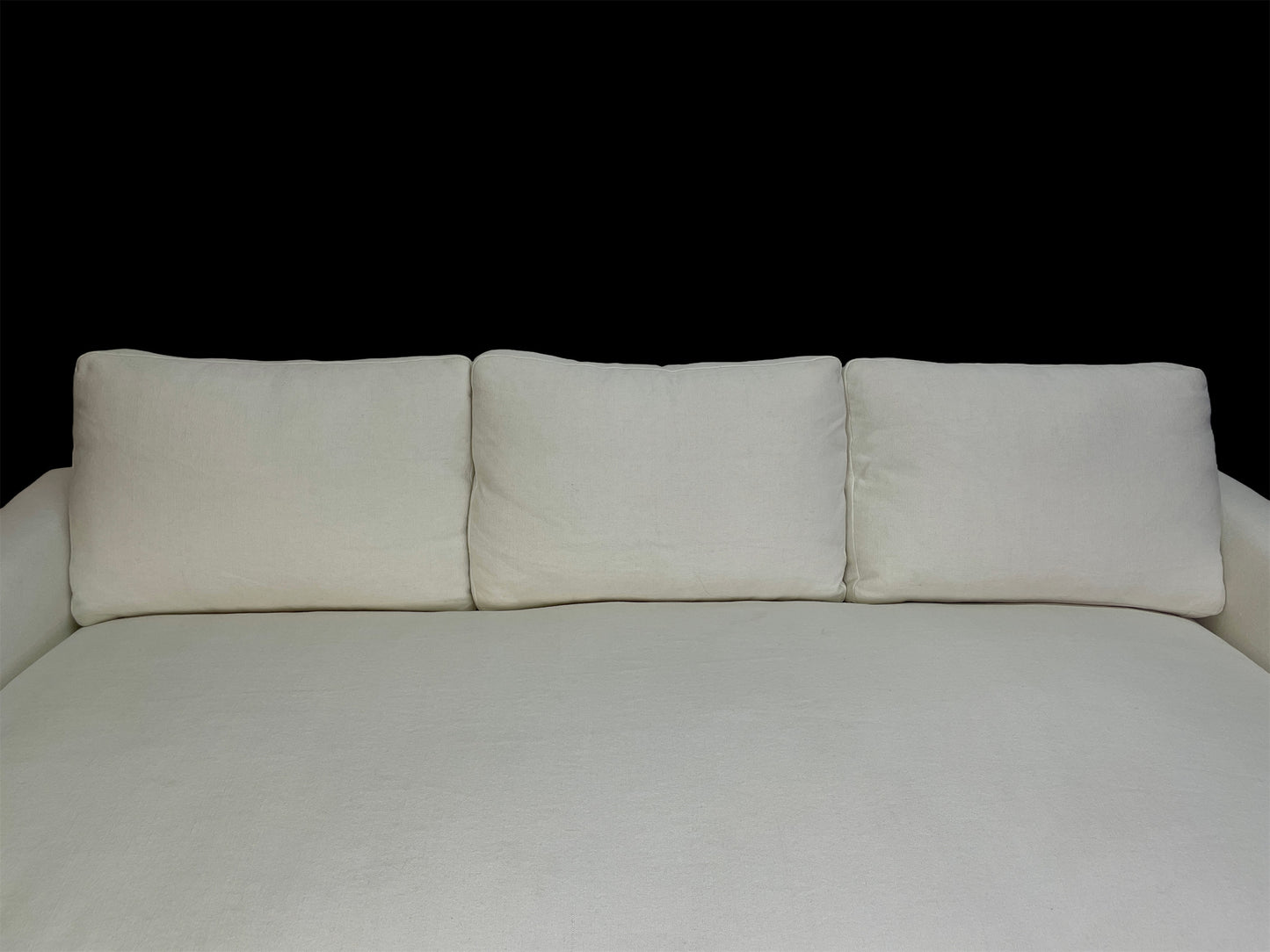 Detail of white cotton upholstery and oversized back cushions on custom contemporary lounge daybed.