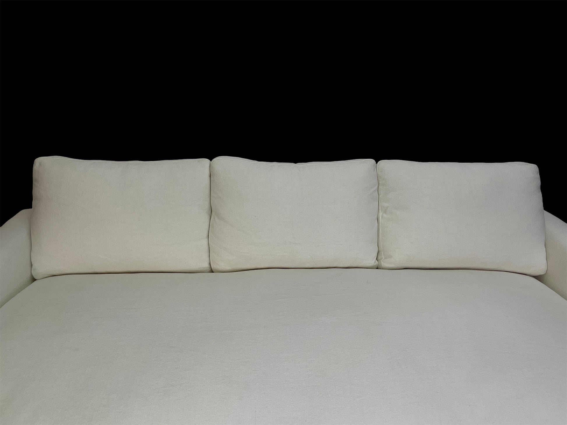 Detail of white cotton upholstery and oversized back cushions on custom contemporary lounge daybed.
