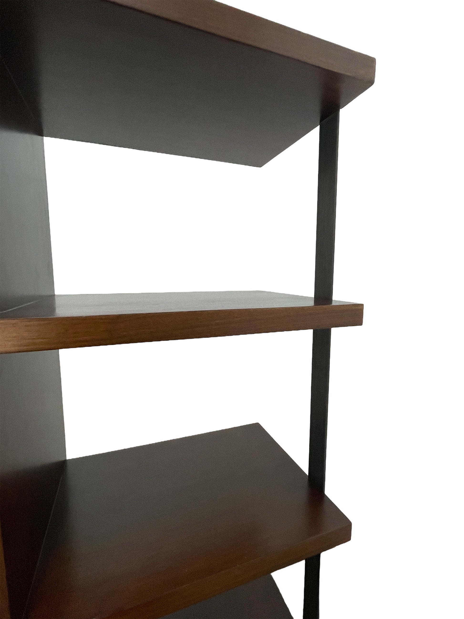 Close-up of integrated metal support reinforcing the open walnut shelving design